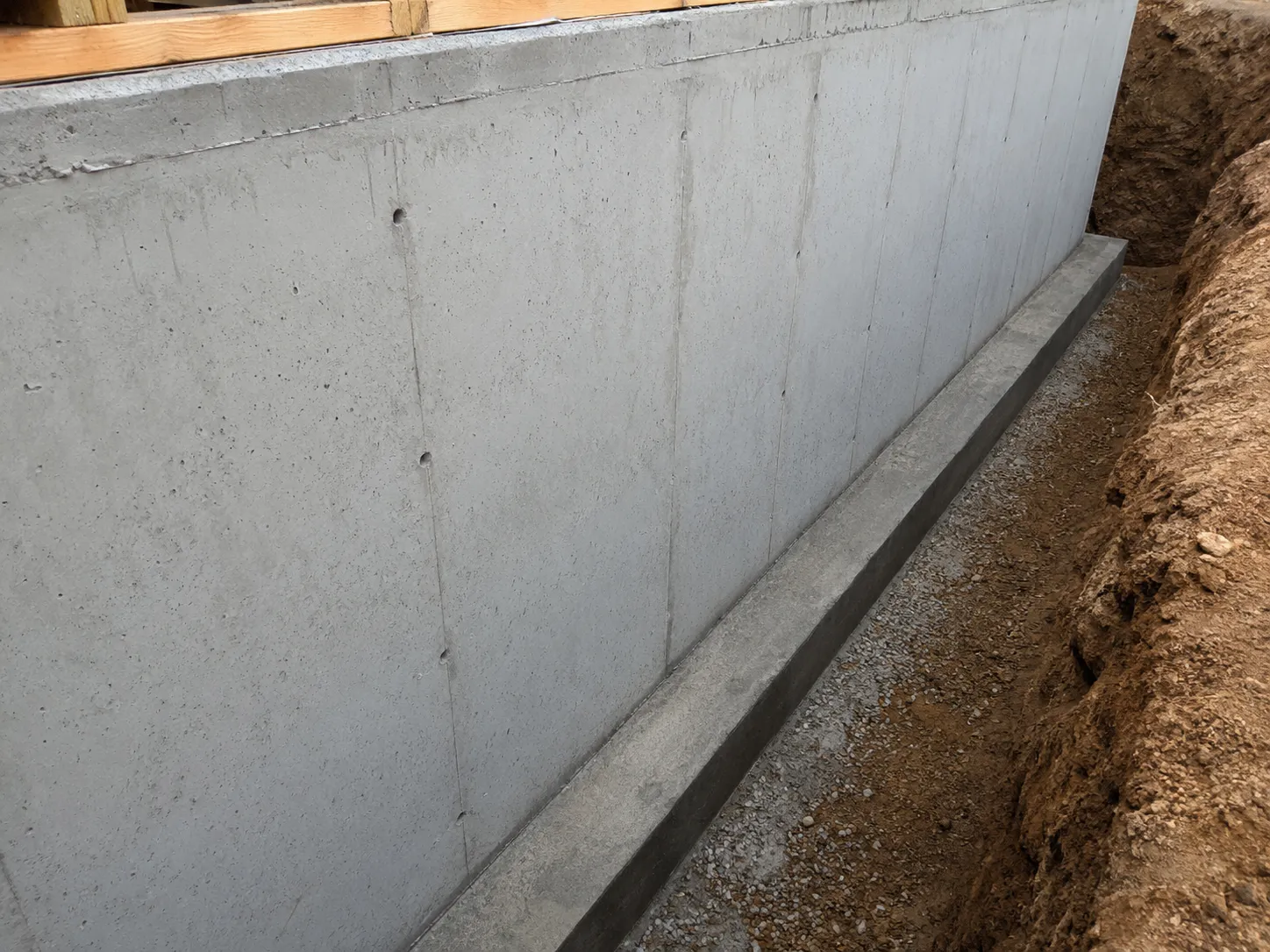 Cleaned and inspected concrete foundation wall ready for membrane application