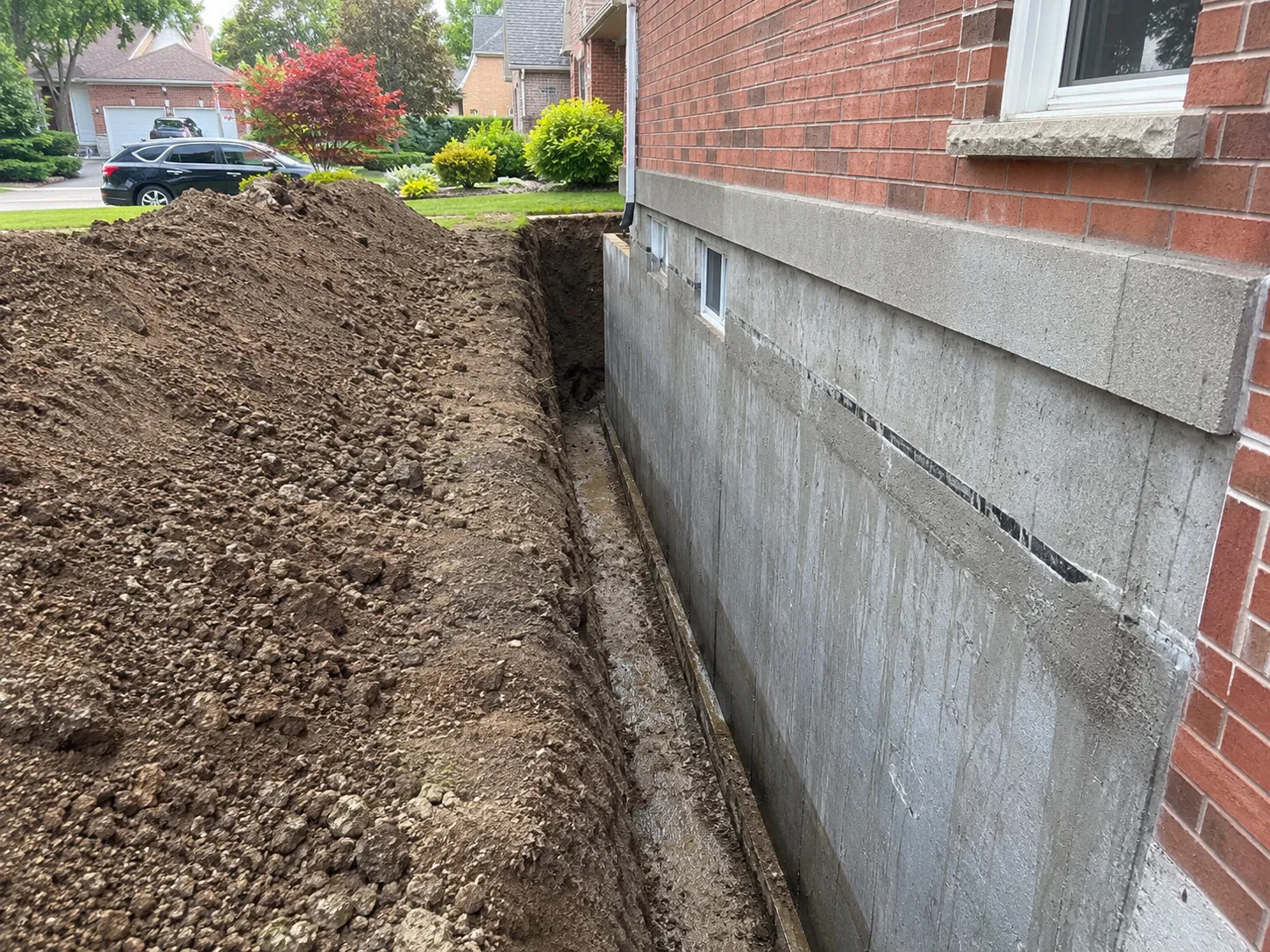 Foundation excavation along Mississauga home exposing concrete wall to footing
